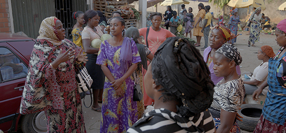 Researcher and peace activist Amina Ahmed in conversation with women in a market in Abuja