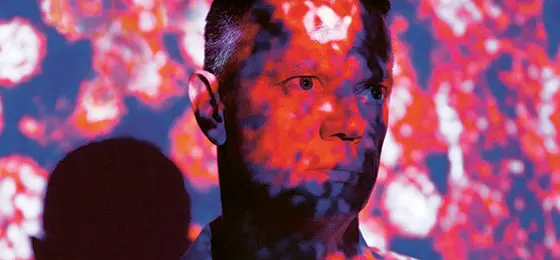 Professor Stefan Kunz with projected Lassa viruses, the pathogens that cause Lassa fever, a common illness in West Africa.