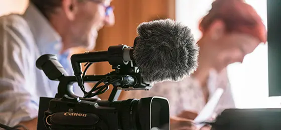 Cette photo montre deux personnes et une caméra.