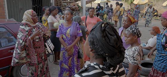 Researcher and peace activist Amina Ahmed in conversation with women in a market in Abuja