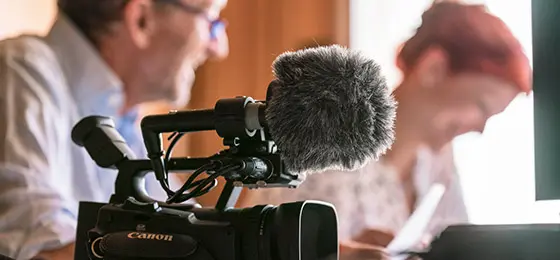 This picture shows two people and a camera. 