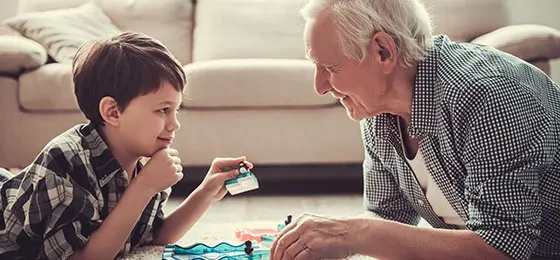La photo montre un homme qui joue avec son petit-fils.