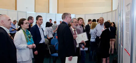 Forscherinnen und Forscher im Gespräch an einer Poster-Präsentation in der rumänischen Nationalbibliothek in Bukarest. © UEFISCD