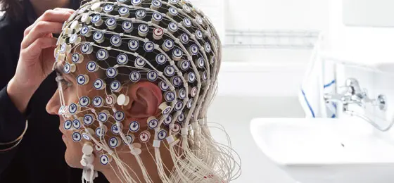 Hirnaktivität der Versuchsperson wird mit Elektroenzephalografie-Helm aufgezeichnet.