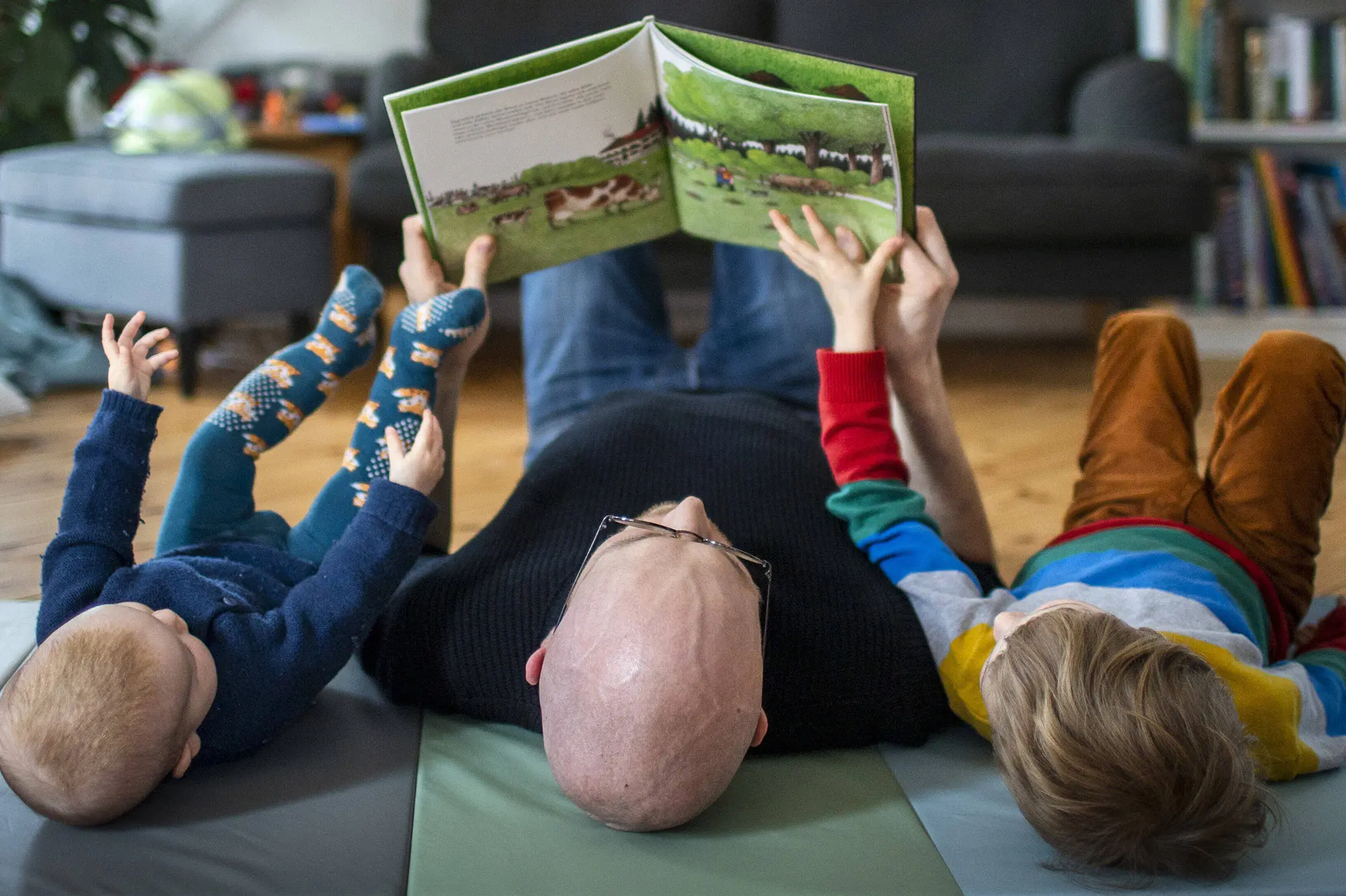 Ein Mann, der zwei Kindern eine Geschichte vorliest.