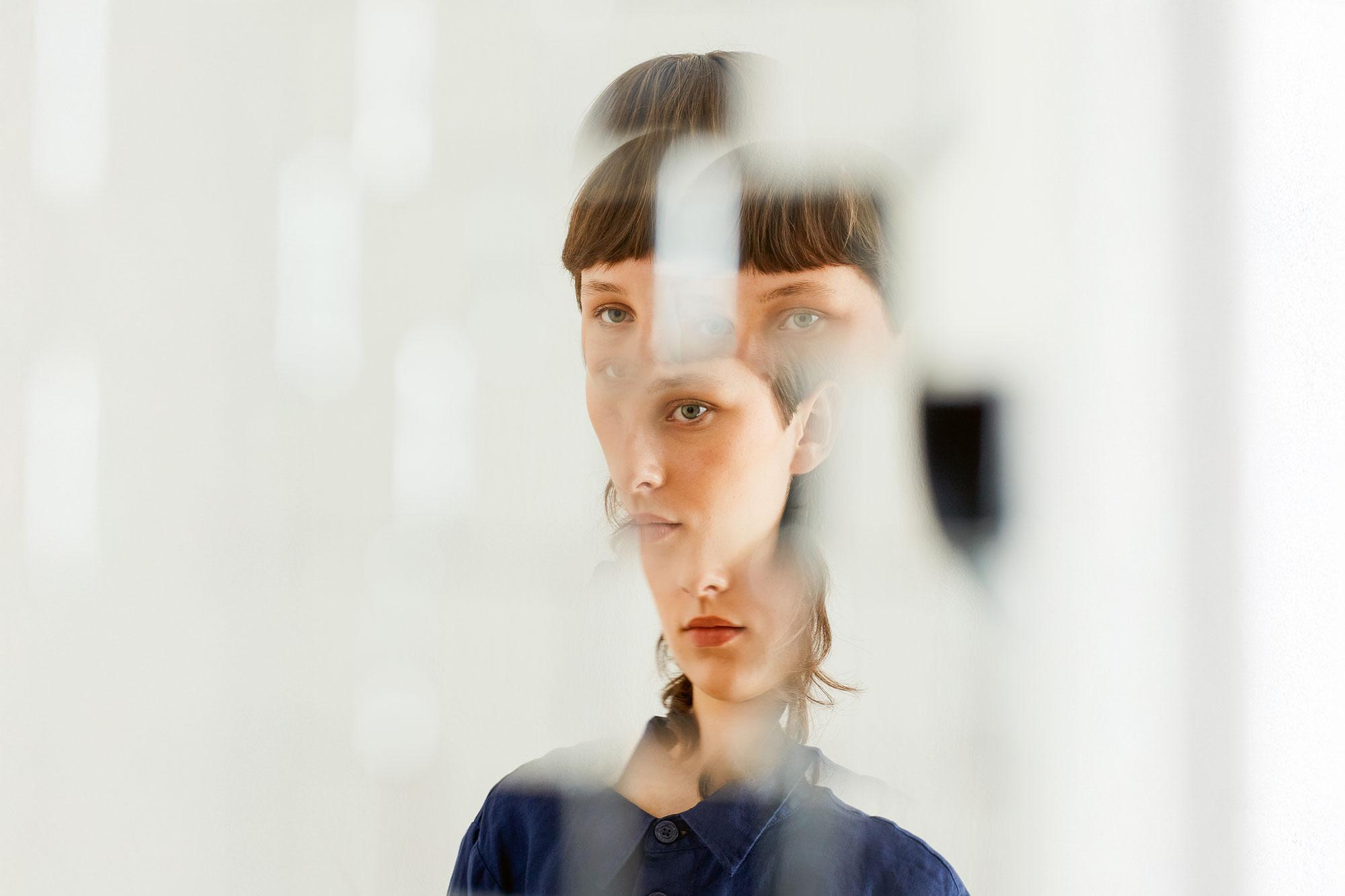 The distorted face of a young woman split into four sections.