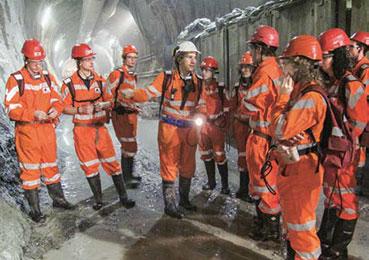 Peter Guntli (with the white helmet) leads geology students through his section of the tunnel.